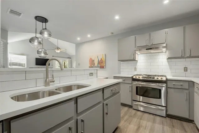 a kitchen with stainless steel appliances granite countertop a sink stove and refrigerator