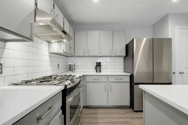 a kitchen with stainless steel appliances granite countertop a sink stove and refrigerator