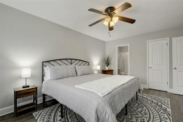 a bedroom with a bed and a lamp on a dresser