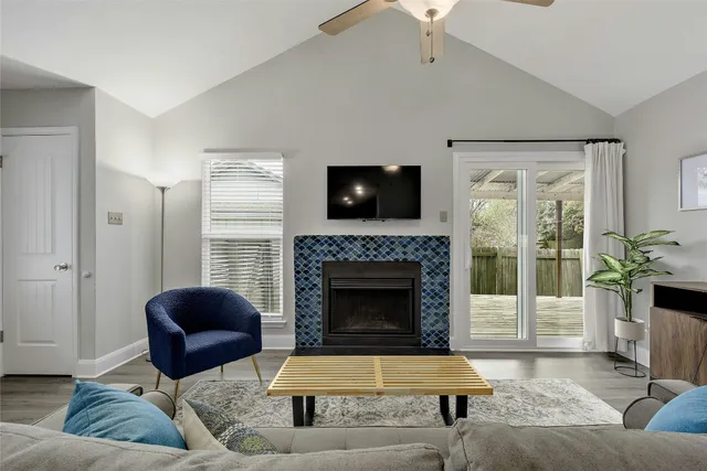a living room with furniture a flat screen tv and a fireplace