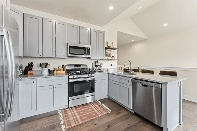 a kitchen with stainless steel appliances granite countertop a stove a sink and a microwave