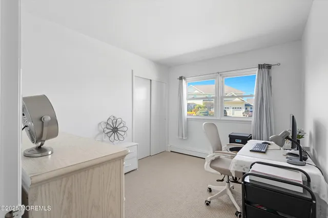 a view of a workspace with furniture and a window