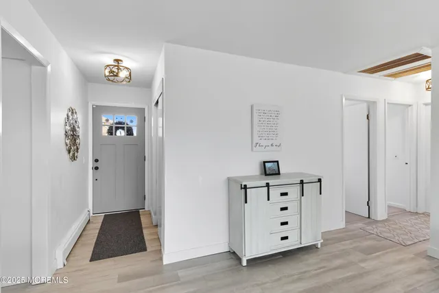 a view of a hallway with closet and wooden floor