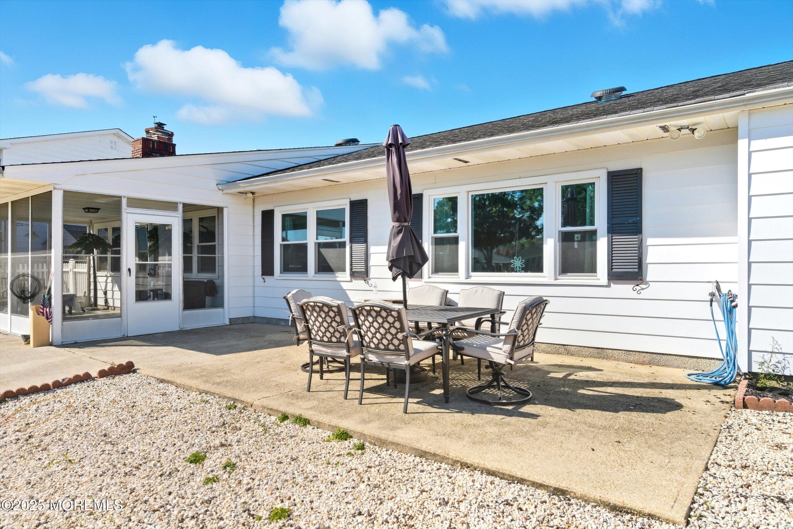 173 Cliff Road Brick, NJ 08724 - Photo 25 of 37 a patio with a table and chairs and potted plants