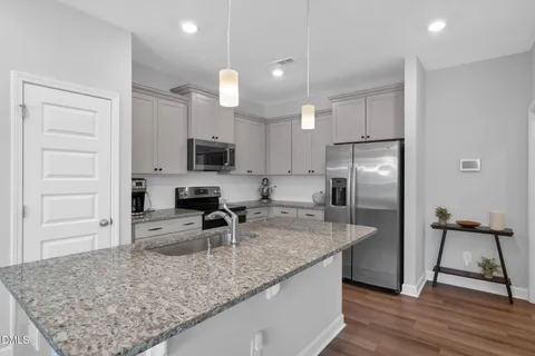 a kitchen with stainless steel appliances granite countertop a sink refrigerator and microwave