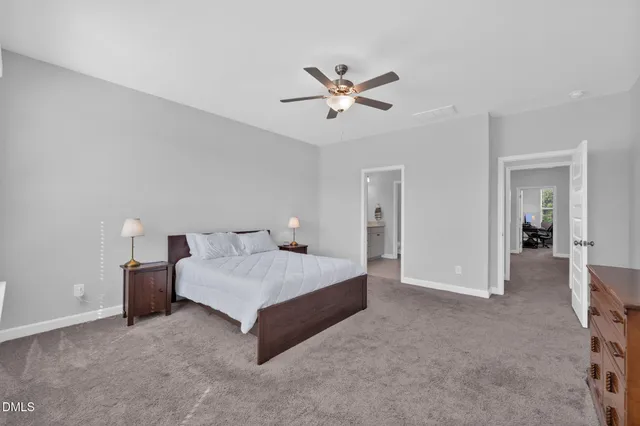 a spacious bedroom with a bed and a chandelier