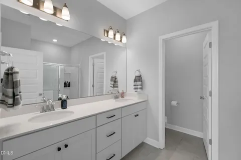 a bathroom with double sink and a mirror