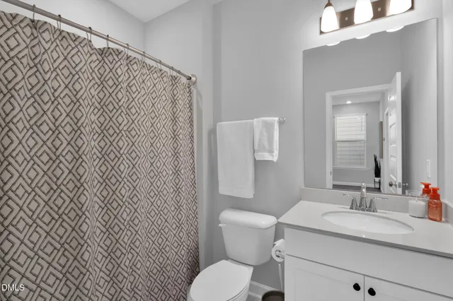 a bathroom with a granite countertop toilet sink and mirror