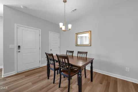a view of a dining room with furniture wooden floor and a chandelier