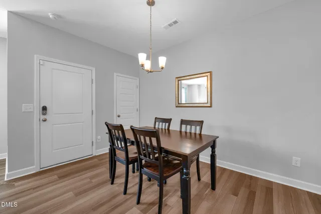 a view of a dining room with furniture wooden floor and a chandelier