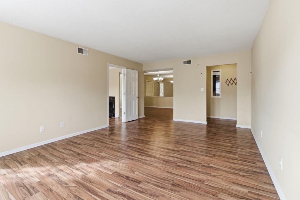 6851 Roswell Road, Unit B15 Sandy Springs, GA 30328 - Photo 12 of 30 a view of an empty room with wooden floor and a window