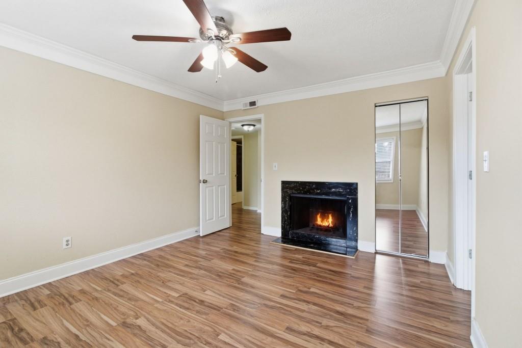 6851 Roswell Road, Unit B15 Sandy Springs, GA 30328 - Photo 15 of 30 a view of an empty room with wooden floor fireplace and a window