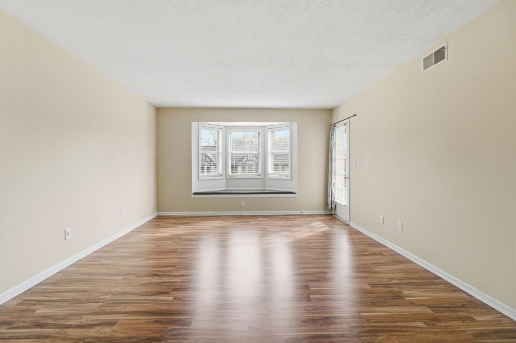 6851 Roswell Road, Unit B15 Sandy Springs, GA 30328 - Photo 24 of 30 a view of an empty room with wooden floor and a window
