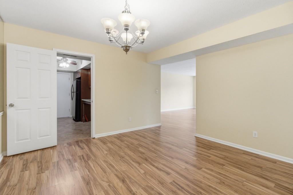 6851 Roswell Road, Unit B15 Sandy Springs, GA 30328 - Photo 6 of 30 a view of a hallway with wooden floor and a chandelier