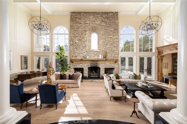 a living room with furniture chandelier and a fireplace
