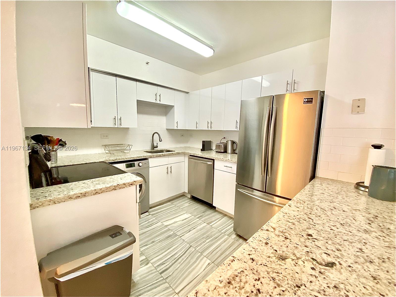 1500 Bay Road, Unit 862S Miami Beach, FL 33139 - Photo 3 of 30 Ample counter space offset by retro-style subway tile backsplash & convenient French refrigerator with freezer on the bottom.