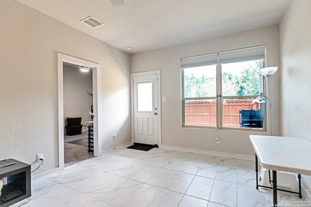 a view of an empty room with a window and bathroom