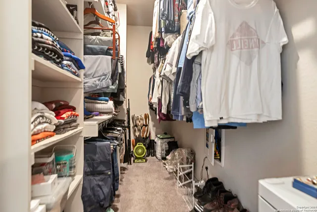 a view of walk in closet with clothes and shoes