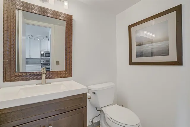 a bathroom with a toilet a sink and mirror