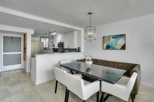 a dining room with a table chairs and kitchen view
