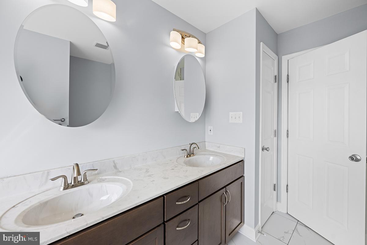 6712 Ridgecrest Road New Market, MD 21774 - Photo 52 of 69 a bathroom with a double vanity sink and a mirror