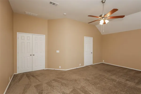 an empty room with windows and fan