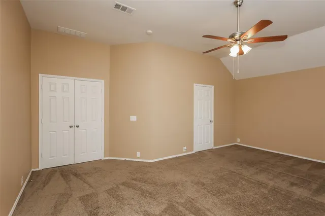 an empty room with windows and fan