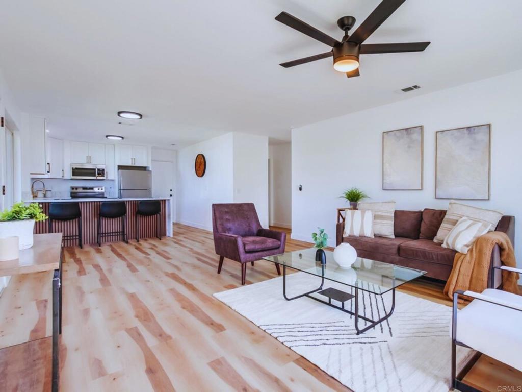 a living room with furniture and a wooden floor