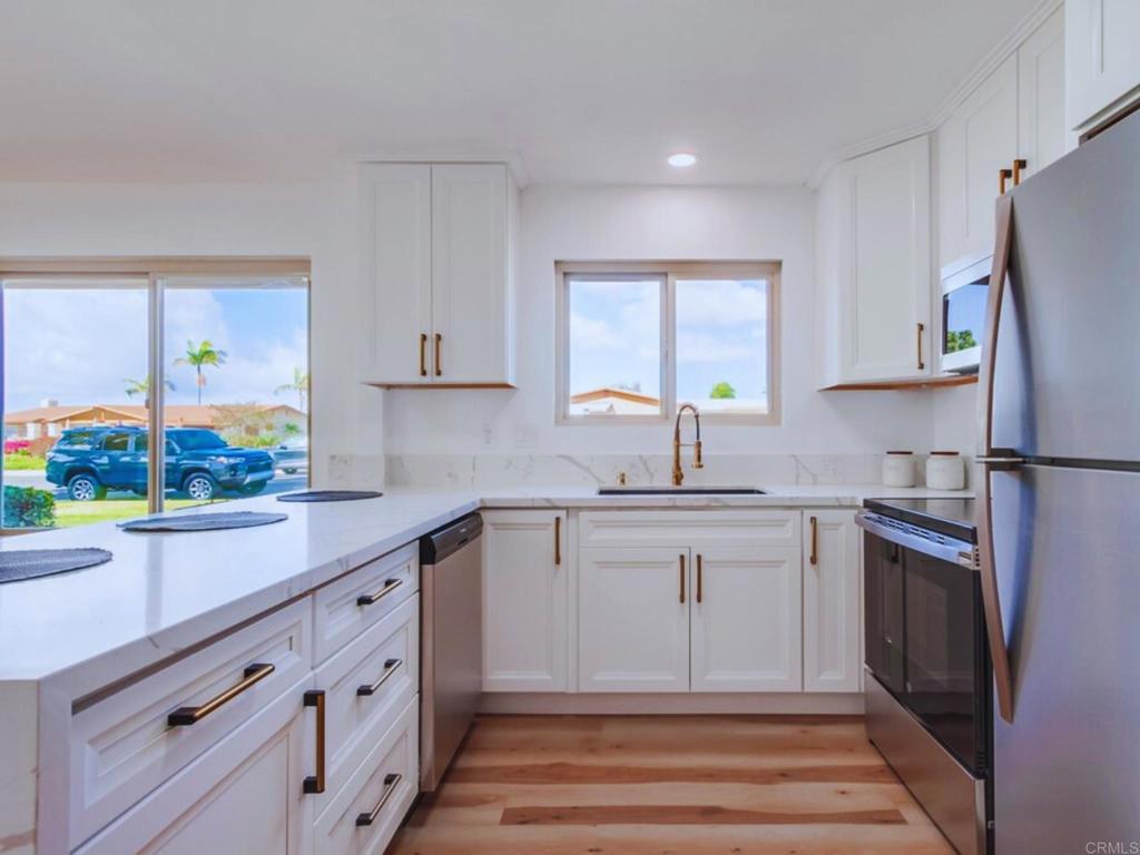 1025 Plover Way Oceanside, CA 92057 - Photo 11 of 36 a kitchen with granite countertop a refrigerator and a sink