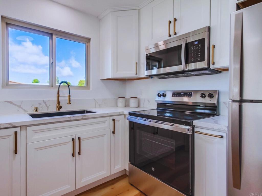 1025 Plover Way Oceanside, CA 92057 - Photo 12 of 36 a kitchen with stainless steel appliances granite countertop a sink stove and microwave