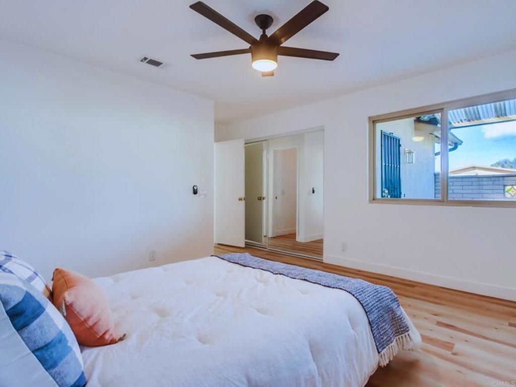 1025 Plover Way Oceanside, CA 92057 - Photo 16 of 36 a bedroom with a bed and a chandelier