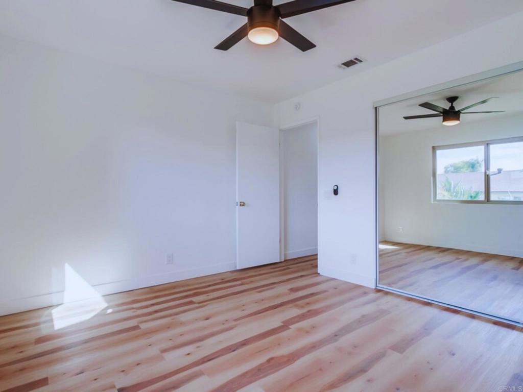1025 Plover Way Oceanside, CA 92057 - Photo 22 of 36 an empty room with wooden floor fan and windows