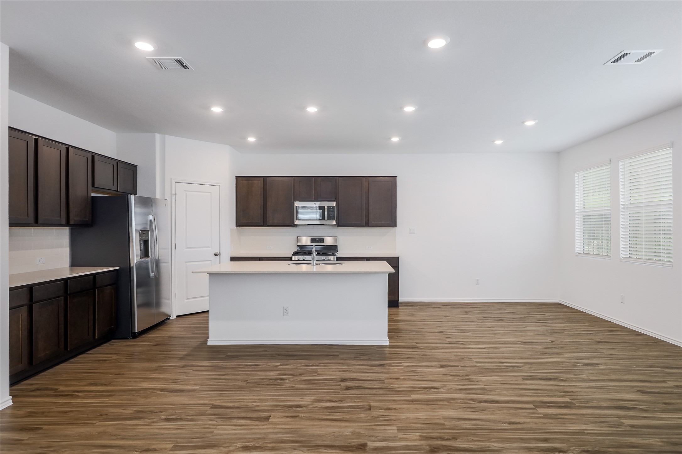 818 Affazia Lane Georgetown, TX 78628 - Photo 7 of 27 a large kitchen with kitchen island a sink stainless steel appliances and cabinets