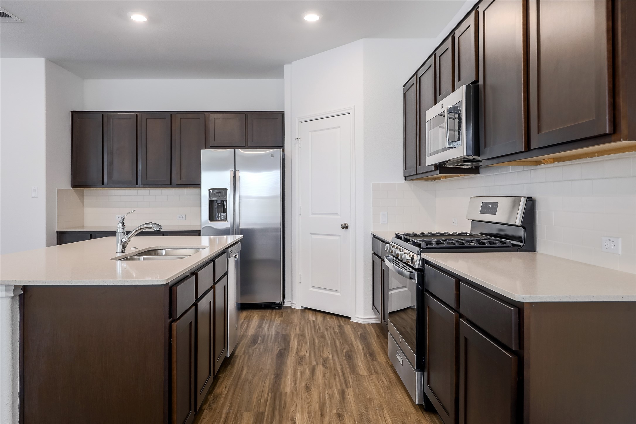 818 Affazia Lane Georgetown, TX 78628 - Photo 10 of 27 a kitchen with stainless steel appliances granite countertop a sink stove and refrigerator