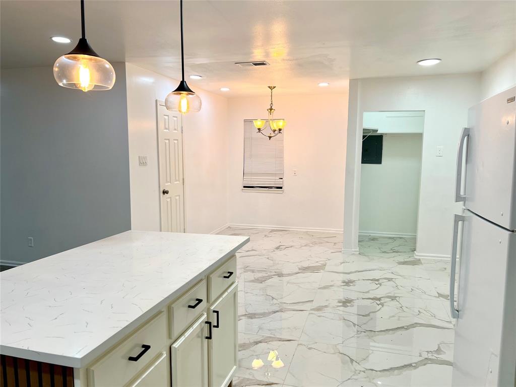2529 Rutgers Drive Irving, TX 75062 - Photo 20 of 38 Kitchen island featuring a white countertop with gray veining and integrated cabinetry