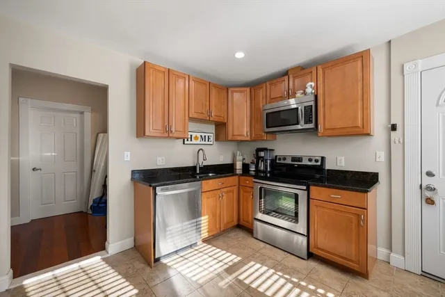 a kitchen with stainless steel appliances granite countertop a stove a sink and a microwave