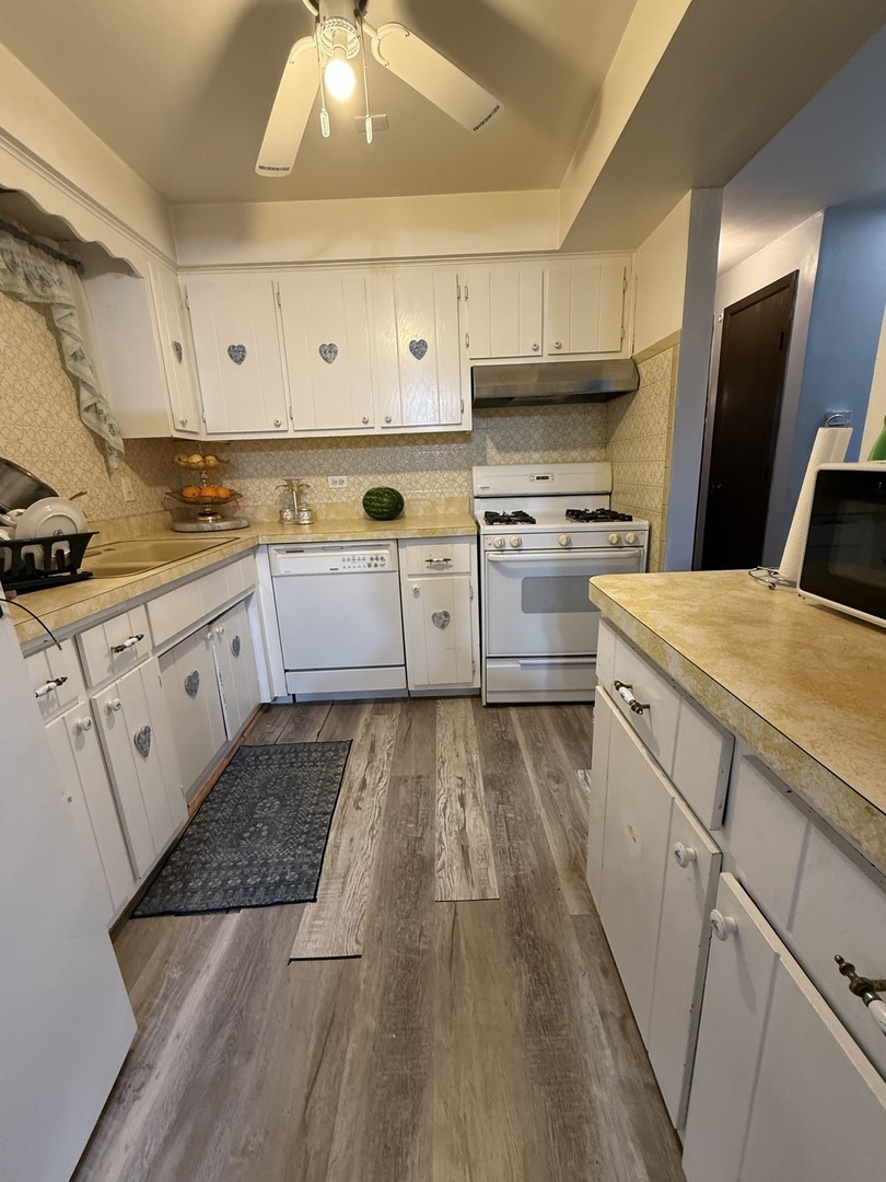 7100 99th Street, Unit 204 Chicago Ridge, IL 60415 - Photo 4 of 9 a kitchen with granite countertop white cabinets and white appliances