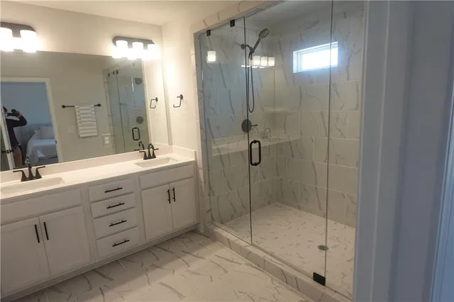 a spacious bathroom with double sink shower and mirror