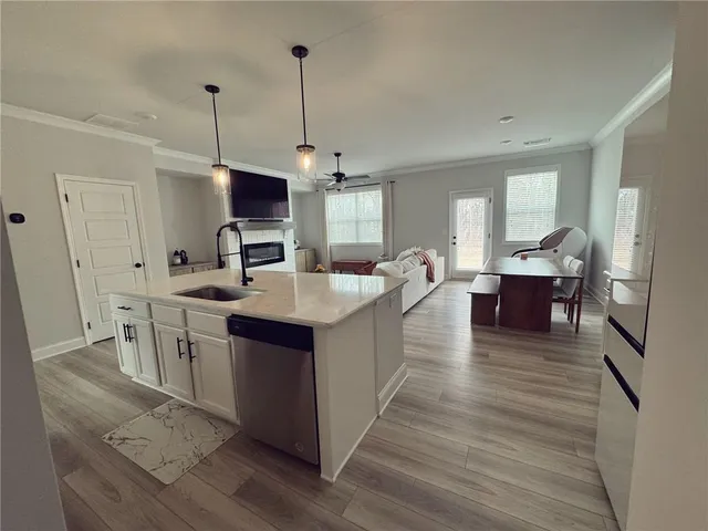 a kitchen with kitchen island a sink and a wooden floor