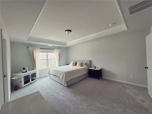 a spacious bedroom with a bed and a window