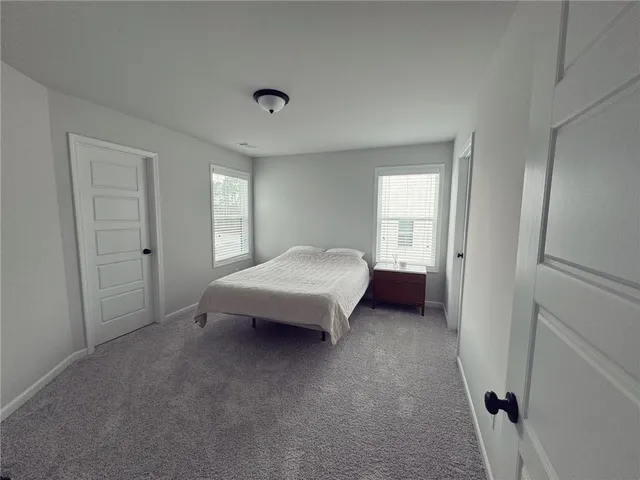 a spacious bedroom with a bed and a window