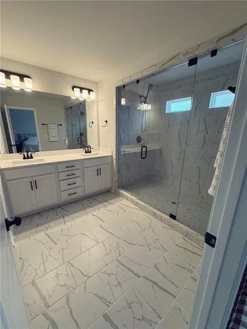 a large bathroom with a tub sink shower and mirror