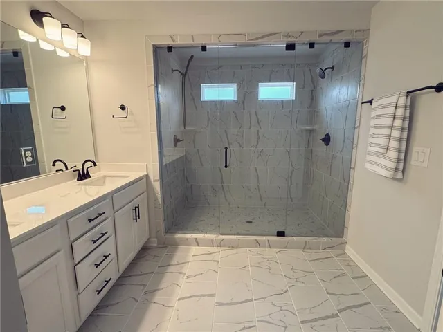 a bathroom with a shower sink and mirror