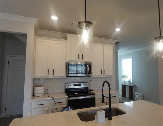 a kitchen with a sink appliances and cabinets