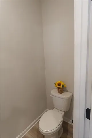 a white toilet sitting next to a white sink and vanity