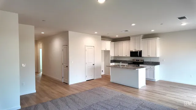 a kitchen with stainless steel appliances granite countertop a stove and a refrigerator