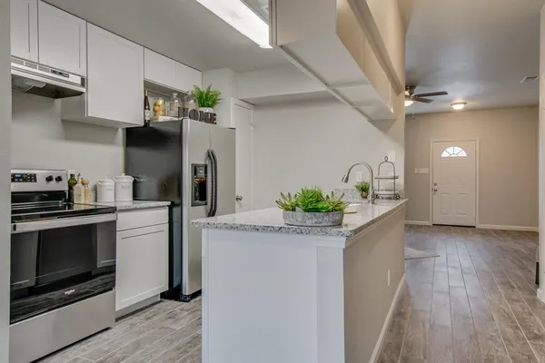 a kitchen with stainless steel appliances granite countertop a sink a stove and cabinets