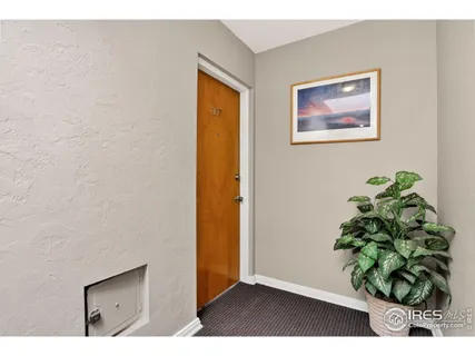 a view of a hallway with wooden floor and a potted plant