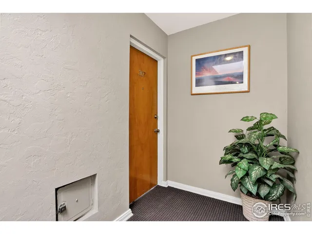 a view of a hallway with wooden floor and a potted plant