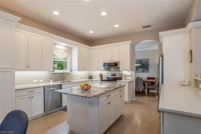 a kitchen with a sink a stove a refrigerator and cabinets